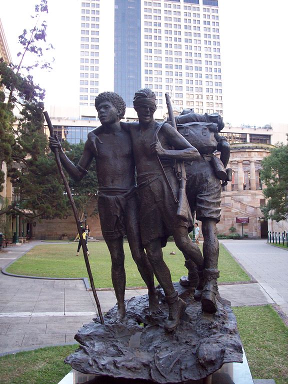 Statue in Brisbane showing Raphael Aimbari leading a blind Australian soldier to safety in New Guinea. (Wikipedia)